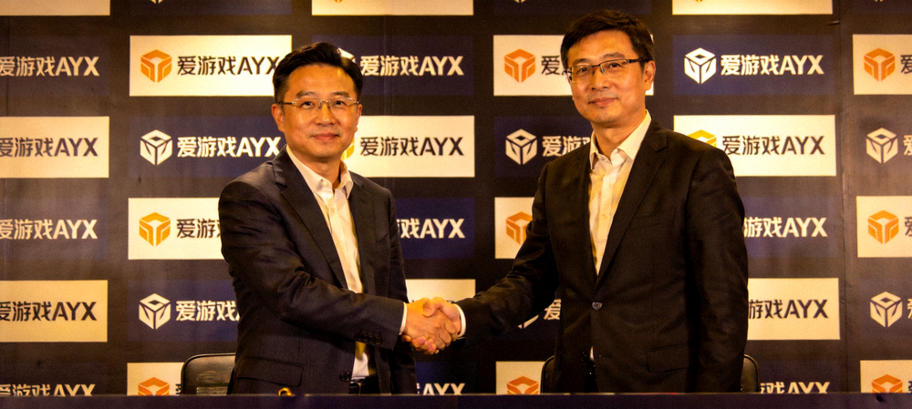 爱游戏AYX与合作伙伴签约仪式 - 双方代表在台上握手，背景是合作品牌logo墙